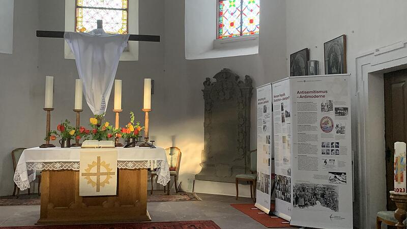 Besonders im Abendlicht beeindruckten Teile der Ausstellung im Altarraum der Evangelischen Dreieinigkeitskirche in Zeitlofs. Der auferstandene Jesus Christus, kreativ mit einem leichten wei&szlig;en Tuch als in der Osternacht auferstanden hervorgehoben,...