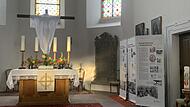 Besonders im Abendlicht beeindruckten Teile der Ausstellung im Altarraum der Evangelischen Dreieinigkeitskirche in Zeitlofs. Der auferstandene Jesus Christus, kreativ mit einem leichten wei&szlig;en Tuch als in der Osternacht auferstanden hervorgehoben,...