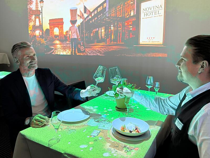 Hoteldirektor Jan Zitzmann (links) und Alexandru Dragos vom Restaurant-Service sto&szlig;en auf den Erfolg des Dinnertheaters im Novina Hotel an.