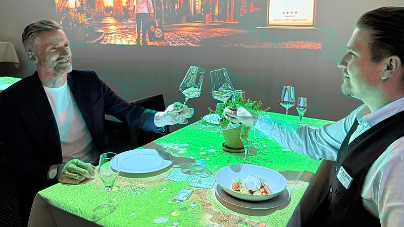 Hoteldirektor Jan Zitzmann (links) und Alexandru Dragos vom Restaurant-Service sto&szlig;en auf den Erfolg des Dinnertheaters im Novina Hotel an.