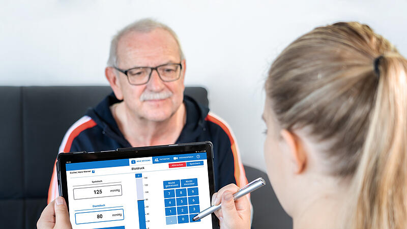 Eine Medizinische Fachangestellte überträgt die Vitalparameter in die Mia-App. Eine Medizinische Fachangestellte überträgt die Vitalparameter in die Mia-App.