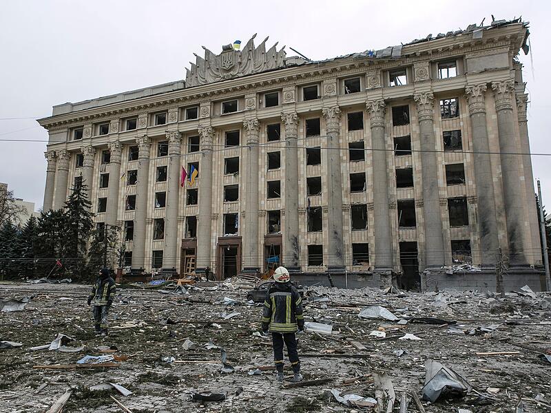 Ukrainische Rettungskräfte stehen vor dem beschädigten Rathausgebäude nach dem russischen Beschuss in der zweitgrößten Stadt Charkiw.