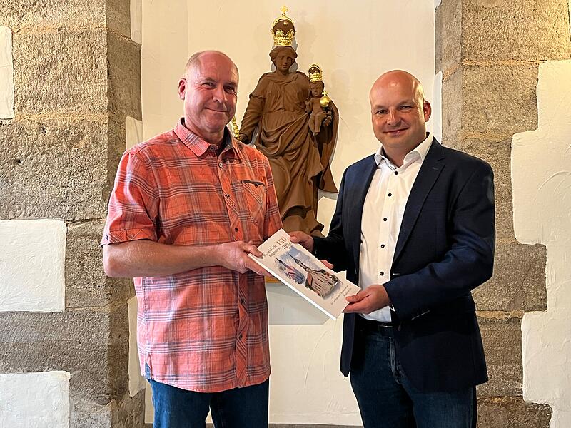 Horst Zakravsky übergibt dem Bürgermeister Michael Kastl seine Kirchenchronik.