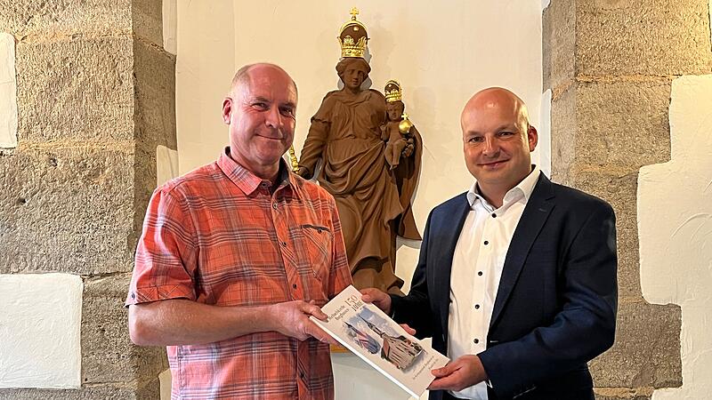 Horst Zakravsky übergibt dem Bürgermeister Michael Kastl seine Kirchenchronik.