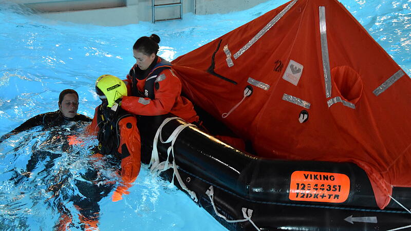 Team Offshoare beim SicherheitstrainingTeam Offshoare beim Sicherheitstraining Menschen in einem Becken mit Wasser und einer Rettungsinsel