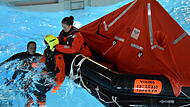 Team Offshoare beim SicherheitstrainingTeam Offshoare beim Sicherheitstraining Menschen in einem Becken mit Wasser und einer Rettungsinsel