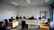 Opferanwältin Antretter, Staatsanwalt Maier, eine Protokollführerin, Strafrichterin Friedmann, Rechtsanwalt Jotschke und der Angeklagte