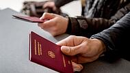 Mann h&auml;lt einen Reisepass in der Hand