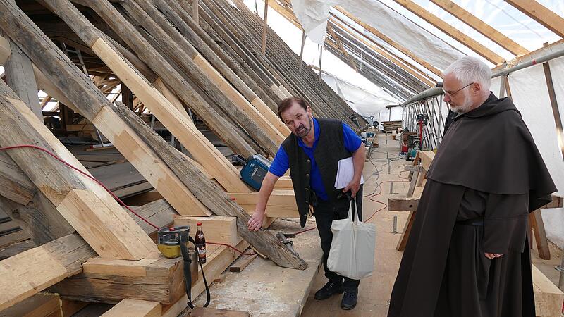 Diplom-Ingenieur Anton Landgraf und Prior Klemens August Droste begutachten die Arbeitsfortschritte im Dachstuhl der Karmelitenkirche.