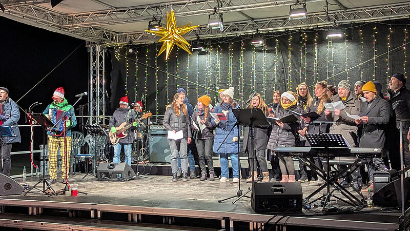 Die beiden Ch&ouml;re &bdquo;Close Harmony & Herzt&ouml;ne&ldquo; verbreiteten Weihnachtsstimmung und animierten zum Mitsingen. Links: David Saam, der musikalische Leiter des Weihnachtssingens.