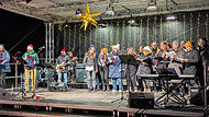 Die beiden Ch&ouml;re &bdquo;Close Harmony & Herzt&ouml;ne&ldquo; verbreiteten Weihnachtsstimmung und animierten zum Mitsingen. Links: David Saam, der musikalische Leiter des Weihnachtssingens.