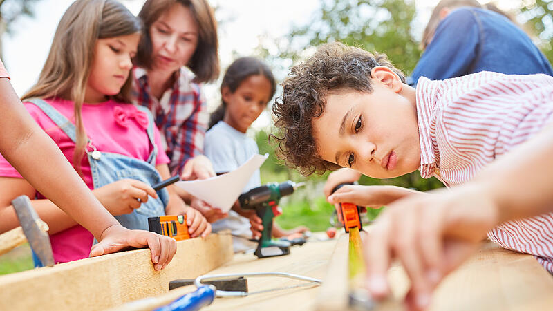 Kinder basteln und werken zusammen mit Holz.