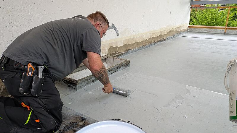 Mirko Köhler von EFT Eschenbacher Flachdachtechnik bringt mit einer Rolle Kemperol auf, um die Terrasse an der Kulmbacher Wolfskehle gegen Wasser abzudichten. Mirko Köhler von EFT Eschenbacher Flachdachtechnik bringt mit einer Rolle Kemperol auf, um die Terrasse an der Kulmbacher Wolfskehle gegen Wasser abzudichten.