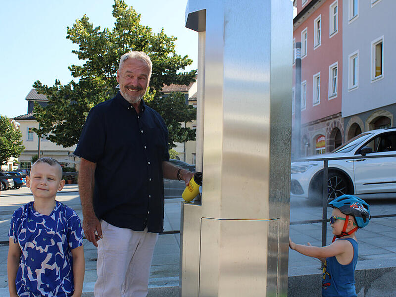 Oberb&uuml;rgermeister Frank Rebhan testet die neue Trinkwasser- und Nebels&auml;ule am Marktplatz.