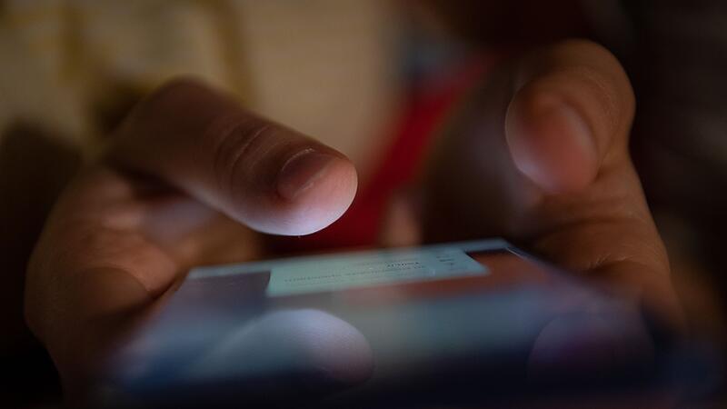 Ein Mann tippt auf einem Smartphone Ein Mann tippt auf einem Smartphone