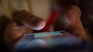 Ein Mann tippt auf einem Smartphone Ein Mann tippt auf einem Smartphone