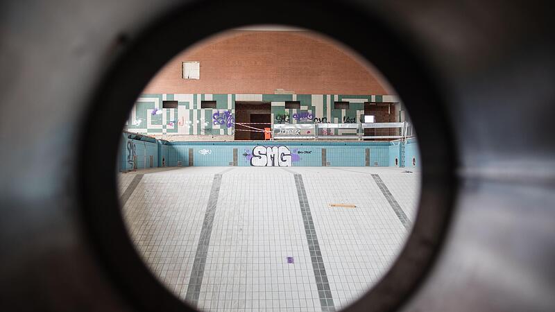 Der Blick durchs Bullauge in das Schwimmbecken des alten Hallenbads. Hier wird bis 2026 unter anderem eine Zweifachsporthalle entstehen. Der Blick durchs Bullauge in das Schwimmbecken des alten Hallenbads. Hier wird bis 2026 unter anderem eine Zweifachsporthalle entstehen.