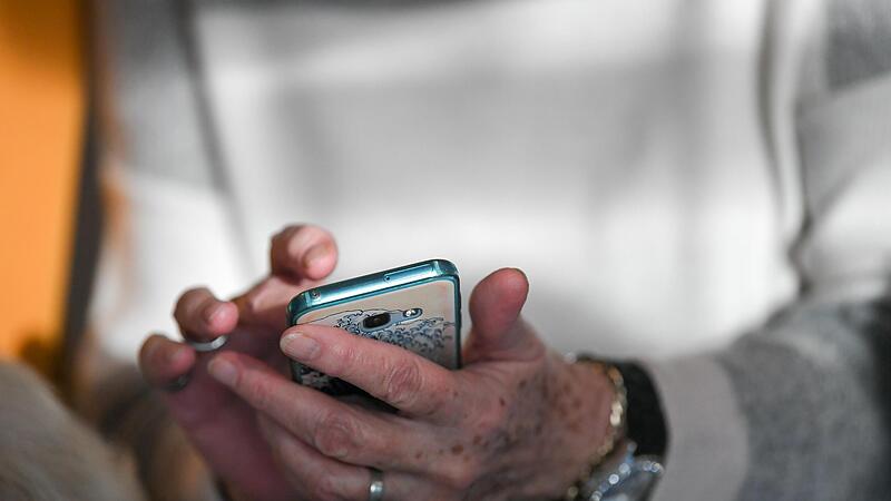 Eine Seniorin h&auml;lt ihr Smartphone in den H&auml;nden.