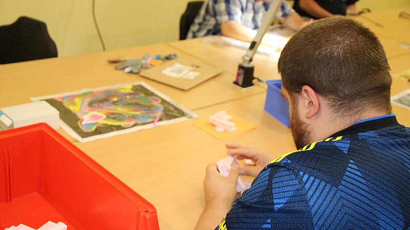 Das  Brückenwerk verschafft Menschen mit psychischen Beeinträchtigungen Arbeit. Hier verpackt ein Mitarbeiter   Teile für ein Kinderspielzeugmodell.