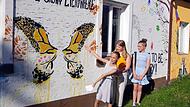 Die M&auml;dchen stellten die Motive der phantasievoll gestalteten Hauswand am Kaulangerplatz vor, darunter diesen Schmetterling, der die Leute zum L&auml;cheln bringen soll.