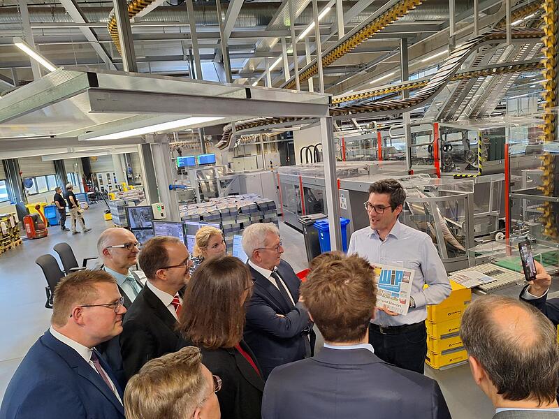 Der Betriebsleiter des Druckzentrums Zsolt Barat (rechts) präsentiert ein Printprodukt.