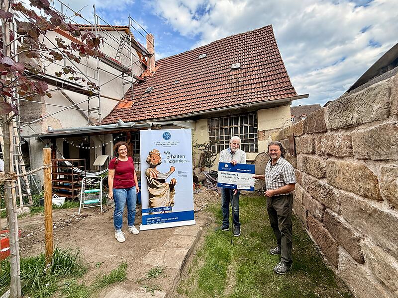 Ortskurator der DSD Herbert van Beek (Mitte) &uuml;bergibt symbolische 35 000 Euro an Robert D&ouml;rfler (rechts). Seine Frau Susann D&ouml;rfler ist auch dabei (rechts).