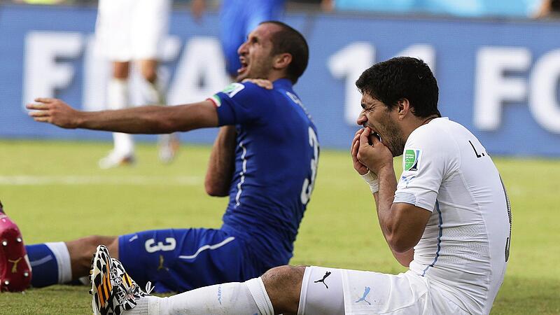 Die berühmteste Beißattacke im Fußball war der Schulterbiss von Luis Suarez (rechts) gegen den Italiener Giorgio Chiellini  (links) bei der WM 2014. Nun hat ein Amateurspieler aus Oberfranken einem Gegenspieler ins Ohr gebissen.