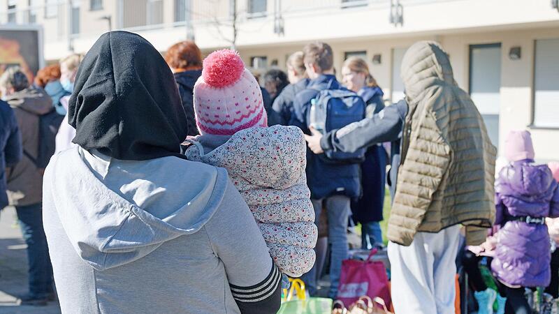 Aus der Ukraine vertriebene Menschen stehen vor einem Fl&uuml;chtlingsheim in K&ouml;ln.