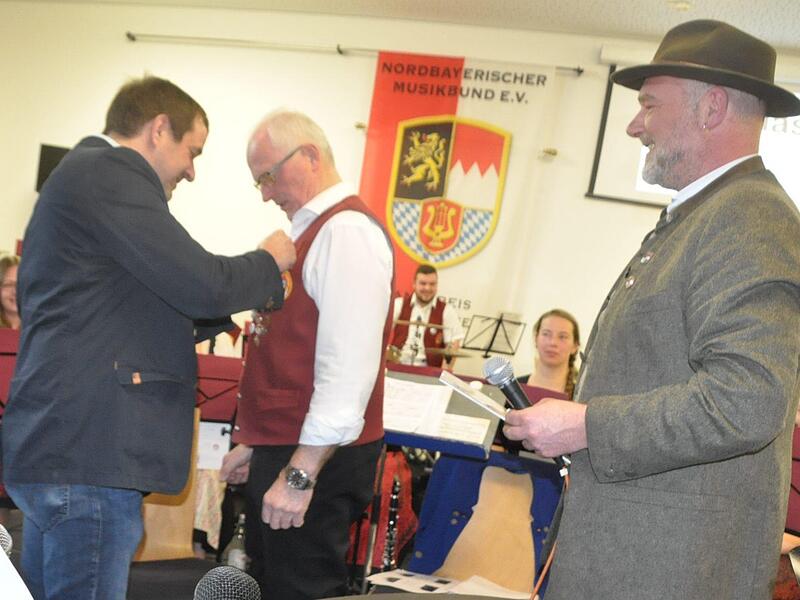 Die Goldene Ehrennadel des Nordbayerischen Musikbundes erhielt Eller für seine 50 Jahre Tätigkeit als Dirigent der Blasmusik Kraisdorf. Kreisvorsitzender Matthias Sperber heftet dem Jubilar die Nadel an, rechts der Vizepräsident des Nordbayerische...
