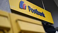 Der Schriftzug der Postbank am Eingang einer Filiale