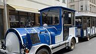 Das Kurb&auml;hnle in Bad Kissingen gibt es aktuell sowohl in gelb-gr&uuml;n, als auch in blau-wei&szlig;. Die gelb-gr&uuml;ne Bahn soll demn&auml;chst aber auch neu lackiert werden, sodass die beiden Z&uuml;ge bald einheitlich blau-wei&szlig; sein werden.