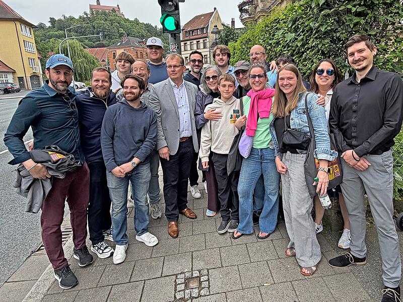 Aus den USA angereist, um die Stadt ihrer Vorfahren zu sehen: Zum Gruppenfoto mit Kulmbachs Oberb&uuml;rgermeister Ralf Hartnack versammeln sich Angeh&ouml;rige der Familie Strauss vor dem Stolperstein f&uuml;r Karl Strauss in der Kronacher Stra&szlig;e 3.