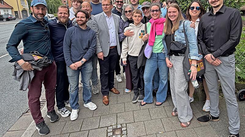 Aus den USA angereist, um die Stadt ihrer Vorfahren zu sehen: Zum Gruppenfoto mit Kulmbachs Oberb&uuml;rgermeister Ralf Hartnack versammeln sich Angeh&ouml;rige der Familie Strauss vor dem Stolperstein f&uuml;r Karl Strauss in der Kronacher Stra&szlig;e 3.