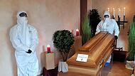 Geschlossener Sarg, Covid-19-Hinweis, Bestatter in Vollmontur. „Ein würdevoller Abschied sieht anders aus“, findet der Höchstadter Bestattungsunternehmer Johannes Riegler.