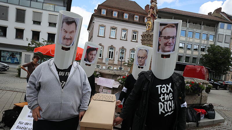 Die Linke zelebrierte am Holzmarkt das Begr&auml;bnis des Sozialstaates und setzten sich Masken mit den Konterfeis von Bundeskanzler Friedrich Merz, Bayerns Ministerpr&auml;sident Markus S&ouml;der, CDU/CSU-Fraktionschef Jens Spahn und Bundesfinanzminister Lars Klingbeil auf.