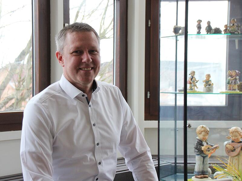 Marco Steiner neben dem Glaskasten mit Hummel-Figuren in seinem B&uuml;ro im Rathaus von R&ouml;dental
