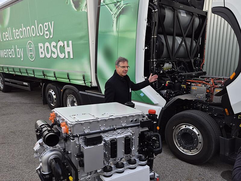 Ein Mitarbeiter bei Bosch Bamberg präsentiert die mobile Brennstoffzelle, die einen großen Lastwagen mit Wasserstoff antreibt.
