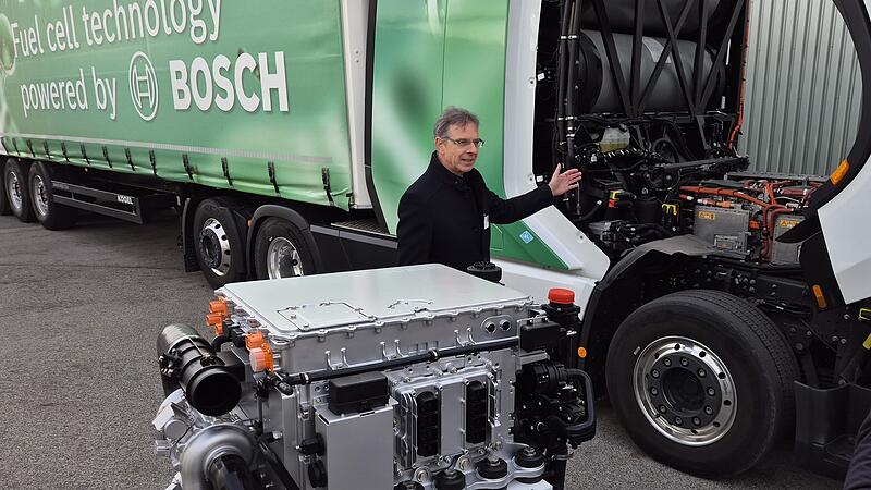 Ein Mitarbeiter bei Bosch Bamberg präsentiert die mobile Brennstoffzelle, die einen großen Lastwagen mit Wasserstoff antreibt.