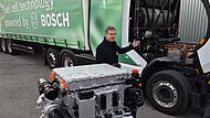 Ein Mitarbeiter bei Bosch Bamberg präsentiert die mobile Brennstoffzelle, die einen großen Lastwagen mit Wasserstoff antreibt.