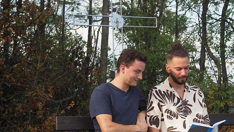 Felix Mann und Lorenz Hofmann lesen die ersten Eintr&auml;ge im Gipfelbuch.Gipfelkreuz Spitzberg