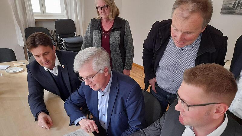 Burgwindheims Bürgermeister Johannes Polenz (rechts) zeigt dem  FDP-Bundesgesundheitspolitiker Andrew Ullmann in einem FT-Beitrag    Gemeinden ohne Hausarzt. Unterstützung erhält er   von Bürgermeisterkollegen Gerd Dallner (links)  und Burgwindhei...