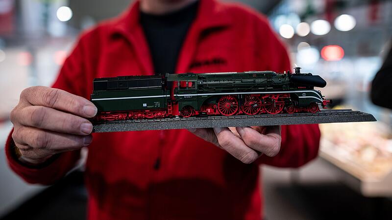 Ein Mann hält eine kleine Lok in die Kamera