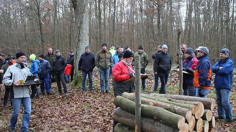 Drei  Schreiber sorgen nach dem Sechs-Augen-Prinzip dafür, dass beim Bieten alles mit rechten Dingen zugeht. Bürgermeister Renè Gerner (2. von rechts mit orange-blauer Jacke) versteigerte das Holz.