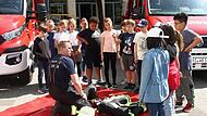 Hier erklärt der Feuerwehrmann den Schülern seine Schutzausrüstung.