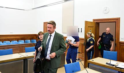 Rechtsanwalt Maximilian Glabasnia aus Bamberg, eine Dolmetscherin, der Angeklagte und seine Polizeieskorte.