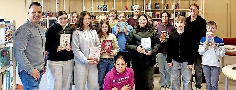 Sch&uuml;lerinnen und Sch&uuml;ler der Sinntalschule freuen sich mit dem Team der Gemeindebibliothek, Heike Kettemer und Sabine Loeber, sowie der Rektorin Christiane Helfrich und dem Gesch&auml;ftsleiter des Marktes Wildflecken, Daniel Kleinheinz, &uuml;ber den neuen...