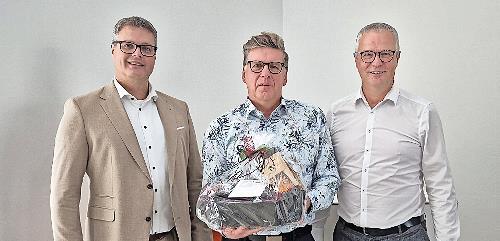 Vorstandsmitglied Markus Feser (links), und Werner Burkard (rechts) verabschieden Matthias Schmitt in den Ruhestand.