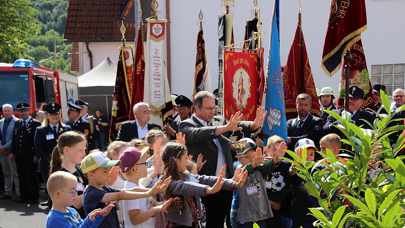 Diakon Manfred M&uuml;ller (Mitte) segnete das neue Fahrzeug der Untererthaler Feuerwehr mit den J&uuml;ngsten der k&uuml;rzlich gegr&uuml;ndeten Kinderfeuerwehr.