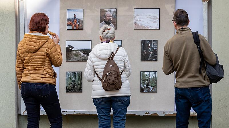 Passanten betrachten in der Kitzinger Innenstadt die besten Pressebilder des Jahres. Seit 2021 findet die Bilderschau nicht mehr ausschließlich in der Rathaushalle statt, sondern wird auch in den Schaufenstern vieler Geschäfte präsentiert. Passanten betrachten in der Kitzinger Innenstadt die besten Pressebilder des Jahres. Seit 2021 findet die Bilderschau nicht mehr ausschließlich in der Rathaushalle statt, sondern wird auch in den Schaufenstern vieler Geschäfte präsentiert.