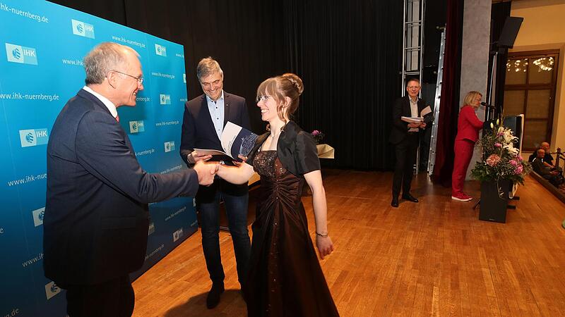 Martin Oberle (links) und Michael Thiem überreichen der   prüfungsbesten Elektronikerin, Svenja Jena, ihr Zeugnis.